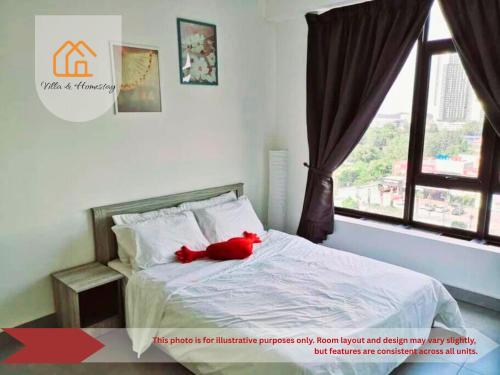 a red teddy bear laying on a bed with a window at ImpianKU at KANVAS SOHO Cyberjaya in Cyberjaya