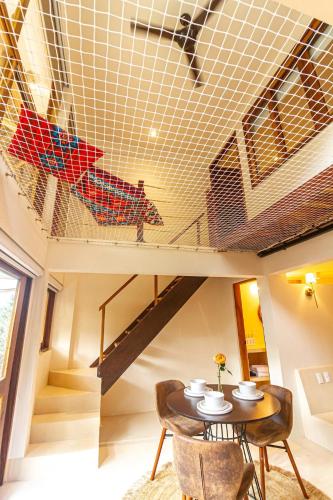 a room with a table and chairs and a staircase at 2 Room Loft, Kitchen, Garden in Mazunte