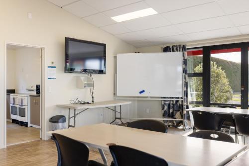 a classroom with tables and chairs and a whiteboard at Kaikōura TOP 10 Holiday Park in Kaikoura
