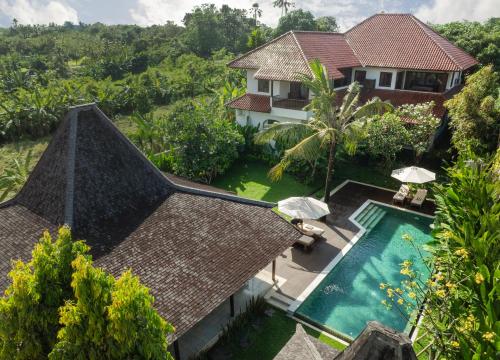 an aerial view of a house with a swimming pool at Villa Tropical Svasti by Nakula in Canggu