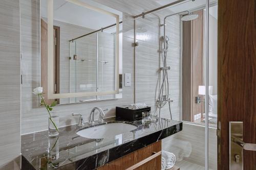 a bathroom with a sink and a mirror at MAISON SEAFRONT RESIDENCE Nha Trang in Nha Trang