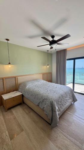 a bedroom with a bed and a ceiling fan at Progreso Luxury Oceanfront Condo at Yucalpetén Resort Marina in Progreso