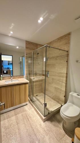 a bathroom with a shower and a toilet and a sink at Progreso Luxury Oceanfront Condo at Yucalpetén Resort Marina in Progreso