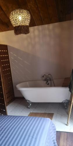 a white bath tub in a room with a bed at Maison 6 personnes au pieds des montagnes à l'Entre-deux in LʼEntre-Deux