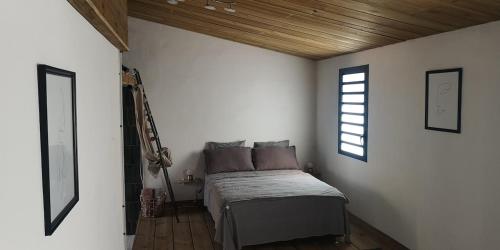 a bedroom with a bed in a white wall at Maison 6 personnes au pieds des montagnes à l'Entre-deux in LʼEntre-Deux