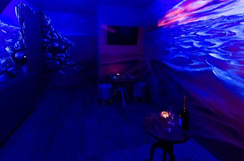 a dark room with a table and a fish tank on the wall at River Lodge Hotel Insolite in Maredsous