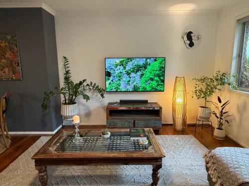 a living room with a coffee table and a flat screen tv at Boongala - Central 3BR pet friendly family home in Maroochydore