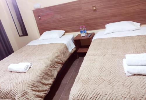 two beds in a hotel room with towels on them at Alojamiento Casca in Huaraz