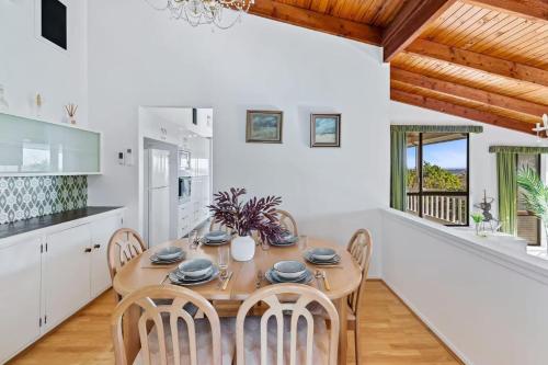 a kitchen and dining room with a wooden table and chairs at Spacious 4BR Retreat With Stunning Brisbane View in Rochedale South