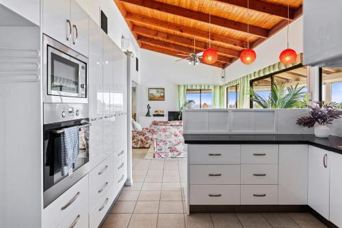 a kitchen with white cabinets and a counter top at Spacious 4BR Retreat With Stunning Brisbane View in Rochedale South