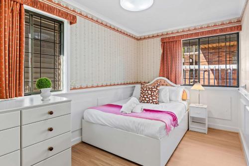 a white bedroom with a bed and a window at Spacious 4BR Retreat With Stunning Brisbane View in Rochedale South