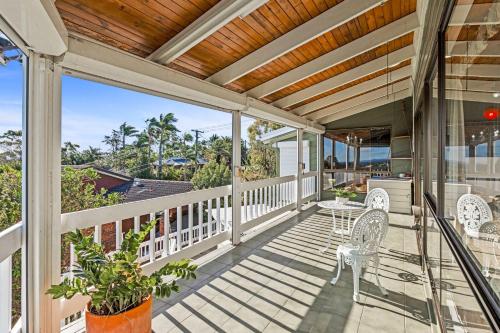 an outdoor deck with chairs and a table and chairs at Spacious 4BR Retreat With Stunning Brisbane View in Rochedale South