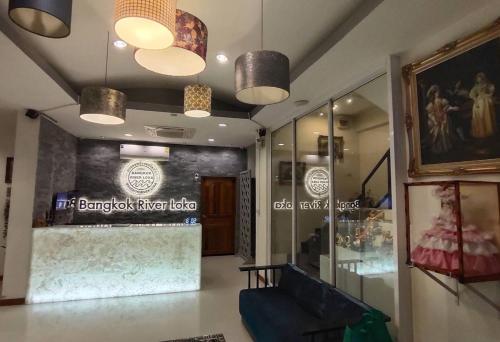 a lobby of a clothing store with two lights at Bangkok River Loka Hotel in Bangkok