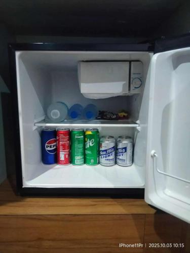 an open refrigerator filled with drinks and soda cans at DUCK INN AND RESTAURANT in Manila