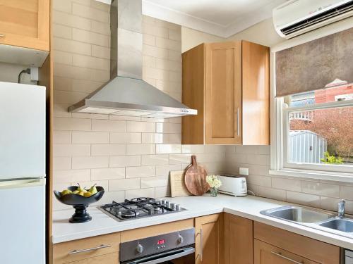 eine Küche mit Herd oberer Ofen neben einer Spüle in der Unterkunft Dawns Cottage in the heart of Daylesford with Fireplace in Daylesford