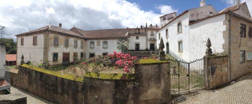 a house with a fence and flowers in front of it at Solar da Roseira in Capinha