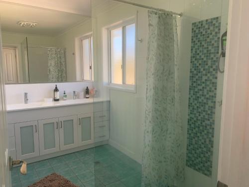 a bathroom with a shower and a sink at Noble House in Tathra