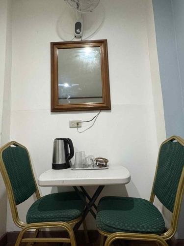 a table with two chairs and a tea kettle on it at duck inn manila in Manila