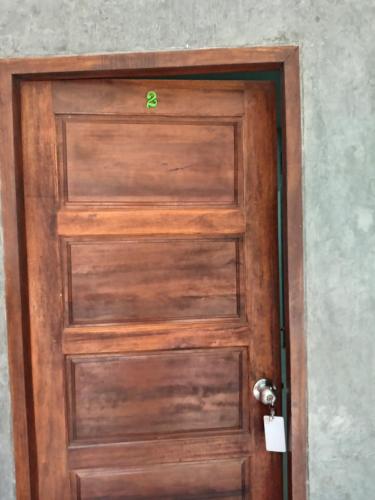 a wooden door with a dollar sign on it at Lantacocogarden in Ko Lanta Yai