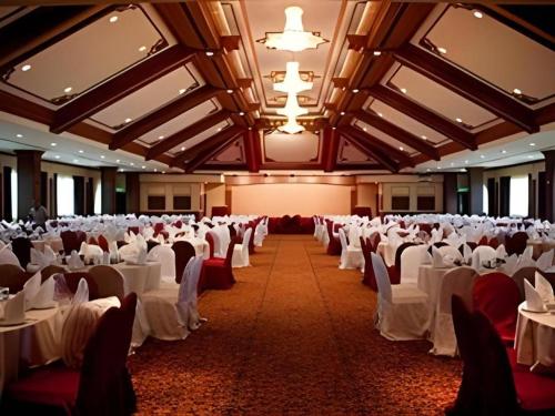 a large banquet hall with white tables and chairs at The CentrePoint Hotel in Bandar Seri Begawan