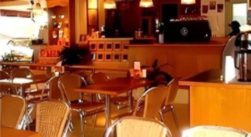 a restaurant with a table and chairs and a bar at The CentrePoint Hotel in Bandar Seri Begawan