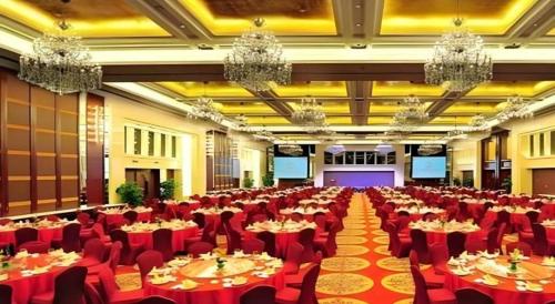a large banquet hall with tables and chairs and chandeliers at Xiangsheng Century Hotel Zhuji in Shaoxing