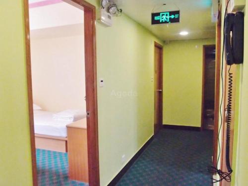 a room with a door leading to a room with a bed at Man Va Hotel in Macau