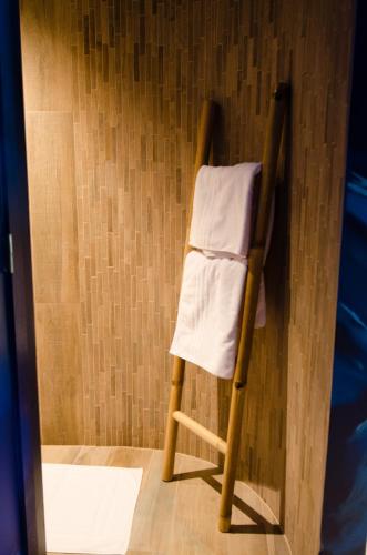 a towel ladder in the corner of a room at River Lodge Hotel Insolite in Maredsous