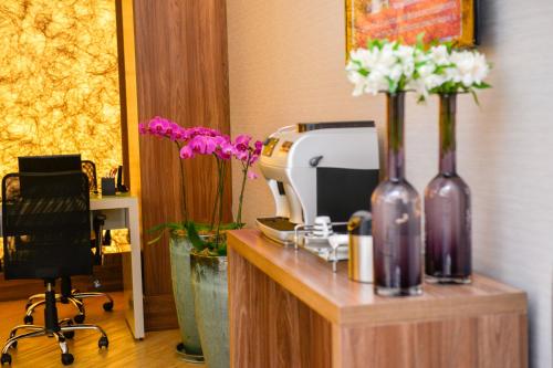 聖保羅的住宿－法利亞利馬克拉麗奧酒店，花瓶装在桌子上的办公室