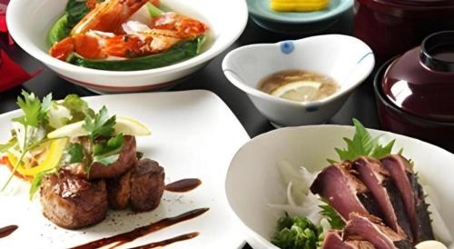 a table with plates of food and bowls of food at Hotel SP Haruno in Kochi