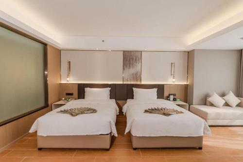a bedroom with three beds and a couch at Chengdu Antai Century Hotel in Chengdu