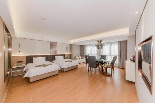 a hotel room with two beds and a dining room at Chengdu Antai Century Hotel in Chengdu