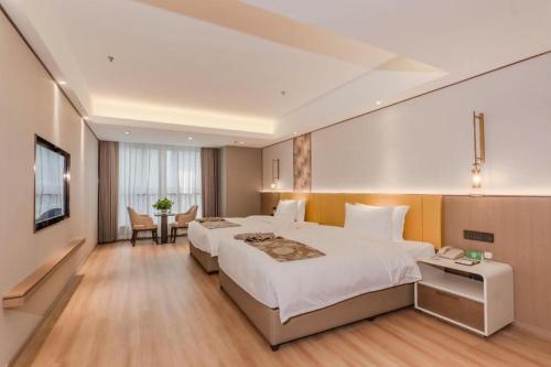 a hotel room with two beds and a television at Chengdu Antai Century Hotel in Chengdu