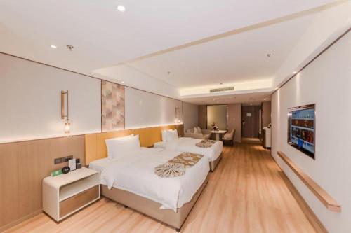 a bedroom with two beds and a flat screen tv at Chengdu Antai Century Hotel in Chengdu