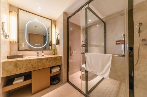 a bathroom with a shower and a sink and a mirror at Chengdu Antai Century Hotel in Chengdu