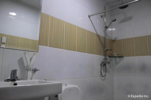 a bathroom with a sink and a shower at Horizon Hotel in Olongapo