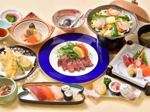 a table topped with plates of food and bowls of food at Hokkaido Futomi Meisen Manyo no Yu in Sapporo