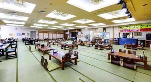 a classroom with tables and chairs in a room at Hokkaido Futomi Meisen Manyo no Yu in Sapporo