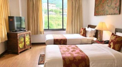 a hotel room with two beds and a flat screen tv at Khang Residency Thimphu in Thimphu