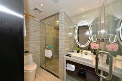 ein Badezimmer mit Waschbecken, Toilette und Spiegel in der Unterkunft Xana Hotelle Guangzhou Tiyuxi Road Metro Station Branch in Guangzhou