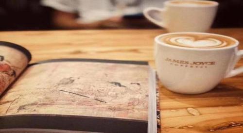 a book and a cup of coffee on a table at James Joyce Coffetel·Anyang Text Museum in Anyang