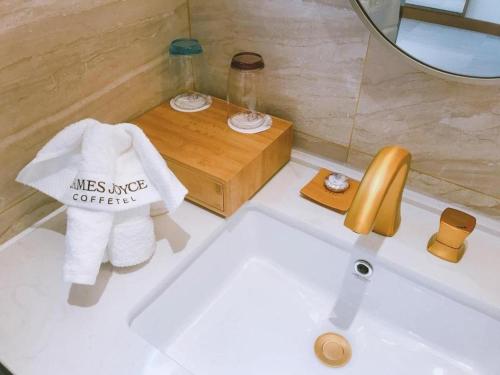 a bathroom sink with a mirror and a towel at James Joyce Coffetel·Anyang Text Museum in Anyang