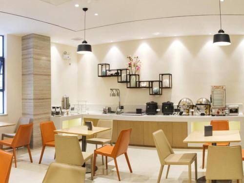 a restaurant with tables and chairs and a counter at City Comfort Inn Beiliu Yongfeng Plaza Chengnan Bus Station in Yulin