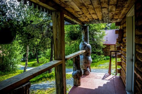 a porch of a cabin with a statue of a bear at Midnight Sun Log Cabins in Moose Pass