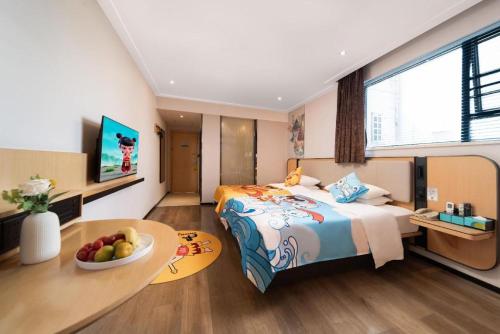 a bedroom with a bed and a bowl of fruit on a table at City Comfort Inn Liuzhou High-speed Railway Station in Liuzhou