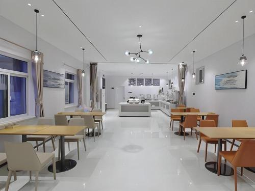 una sala da pranzo con tavoli e sedie in legno di City Comfort Inn Jinan West Station Shandong International Convention and Exhibition a Jinan