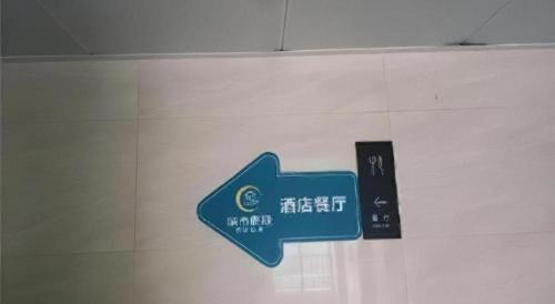 a blue arrow sign on a white wall at City Comfort Inn Wuhan International Expo Center Yongwang in Wuhan