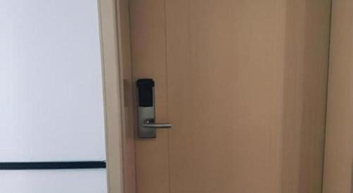 an open door with a metal handle on it at City Comfort Inn Wuhan International Expo Center Yongwang in Wuhan