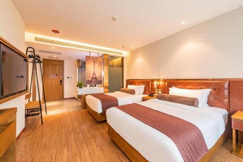 a hotel room with two beds and a television at James Joyce Coffetel Shijiazhuang the Mixc Jinyuan Tower Airport Bus in Shijiazhuang