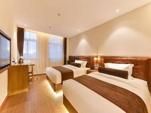 a hotel room with two beds and a flat screen tv at James Joyce Coffetel Shijiazhuang the Mixc Jinyuan Tower Airport Bus in Shijiazhuang
